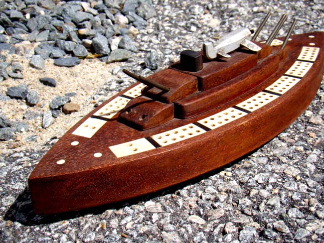 Possibly unique early 20th century bone inlaid cribbage board in the form of a Battleship with deck mounted plane.